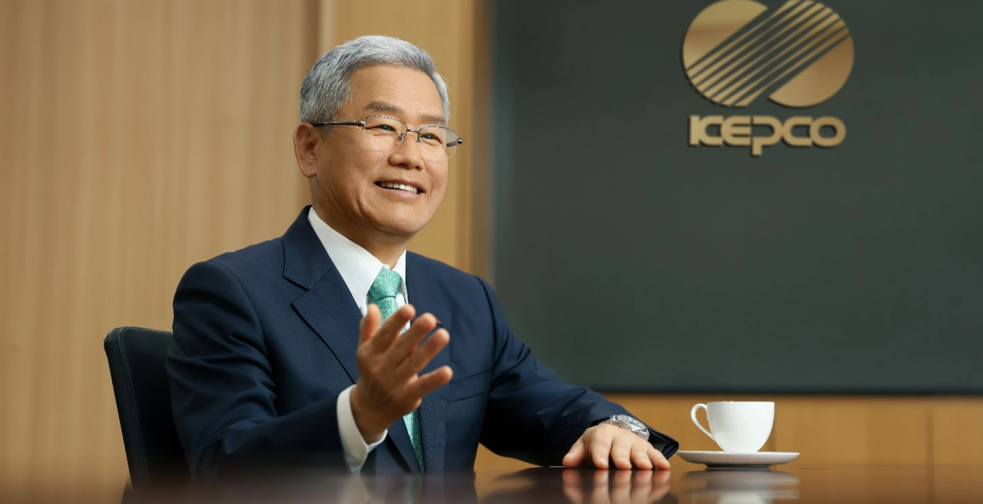 오른손을 들며 웃고있는 김동철 사장