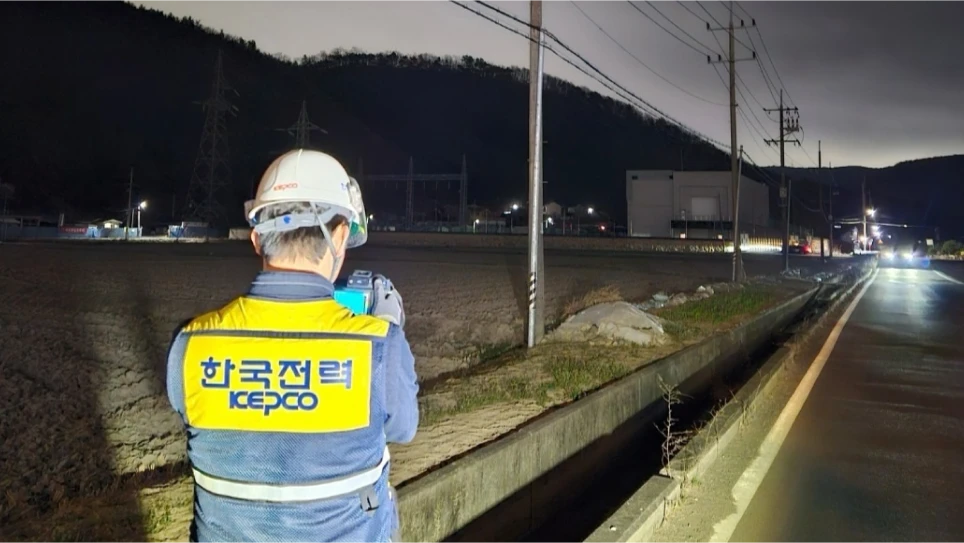 야간에 정전 원인을 점검하고 있는 한국전력 직원의 뒷모습 사진