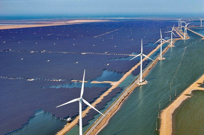 Solar panels and wind turbines in the city of Binzhou in China’s Shandong province on June 11 (AFP)